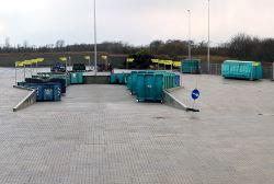 En flisebelagt plads med containere