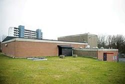 Vognsbøl vandværk - Rød bygning med hvidt højhus i baggrunden.